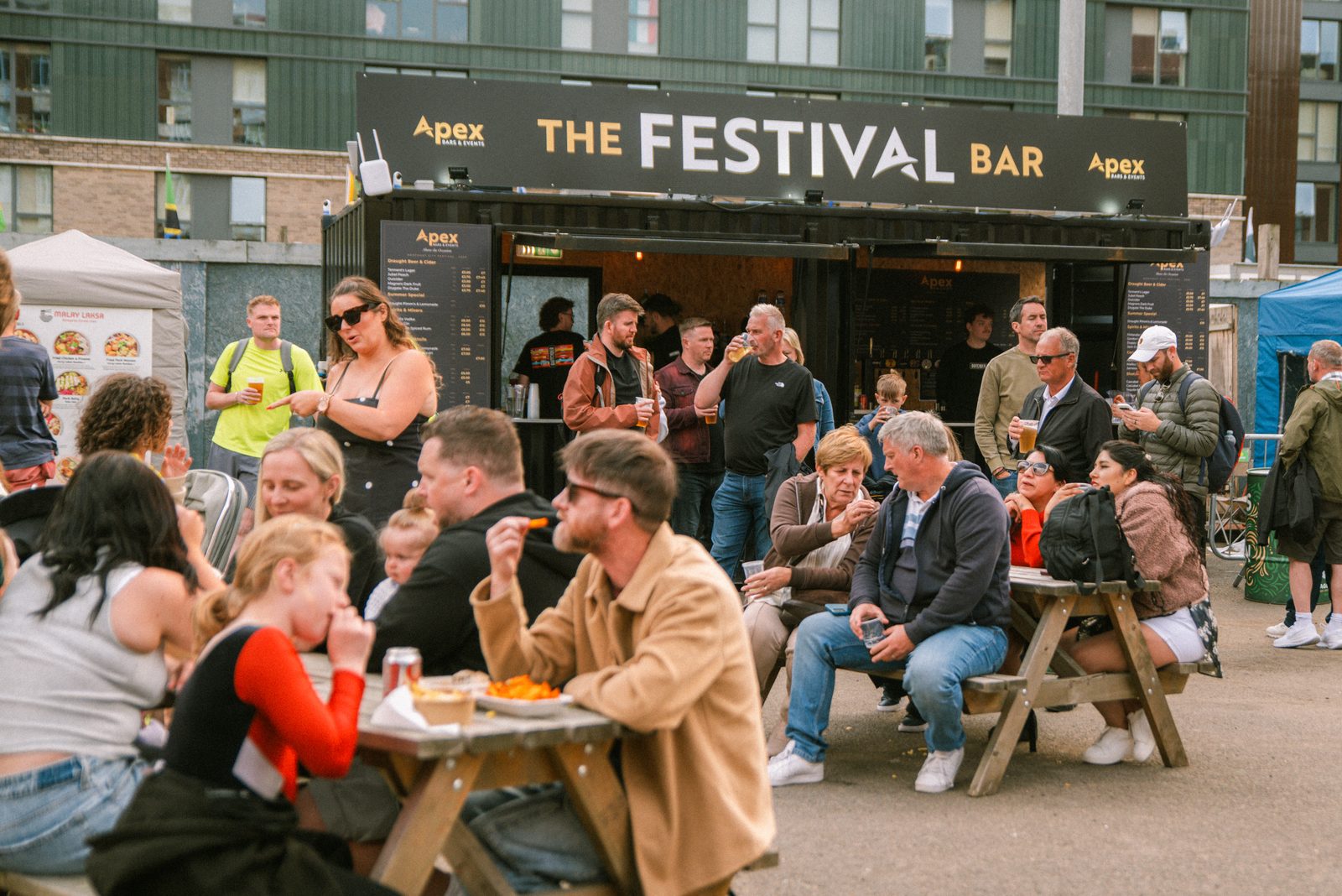 Guests at picnic benches outside The Festival Bar